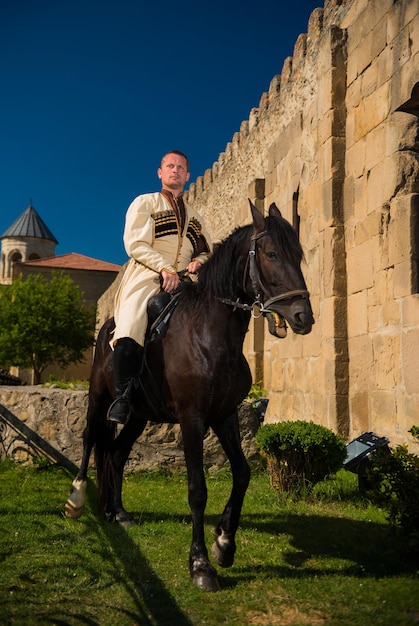 En Georgia, el vestido nacional en un caballo cerca del Castillo