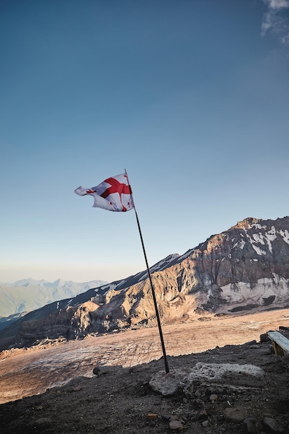 Georgische Nationalflagge mit Blick auf den Gergeti-Gletscher Meteostation in Kazbek Georgia Mount kazbek alpinist expedition