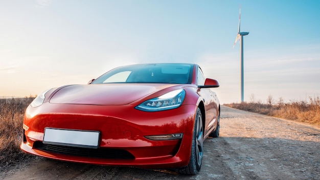 Geparktes rotes Tesla Model 3 bei Sonnenuntergang