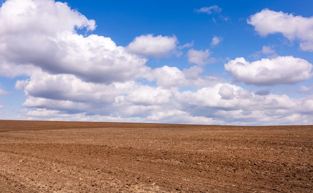 Gepflügtes Feld mit schönen Wolken