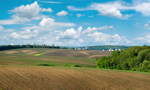 Gepflügtes Feld und Hügel in einer ländlichen Landschaft im Frühling