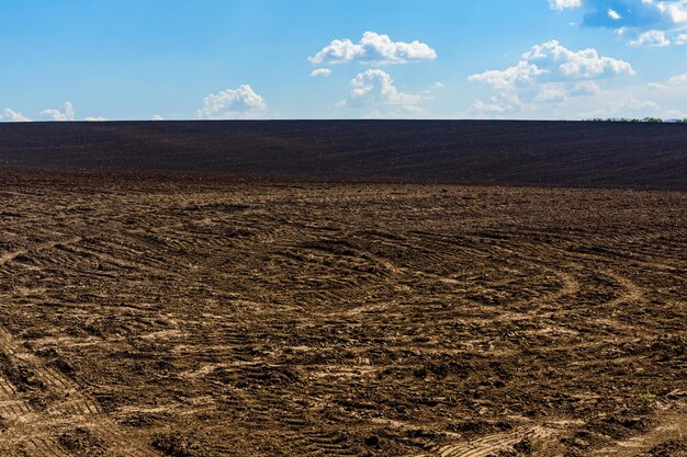 Gepflügtes landwirtschaftliches Feld im Sommer Ländliche Landschaft