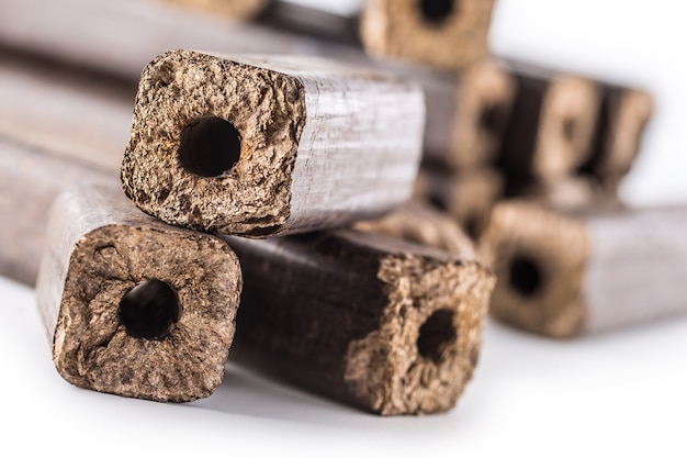 Gepresste Holzbriketts Pini Kay aus Biomasse auf einem weißen, isolierten Hintergrund.