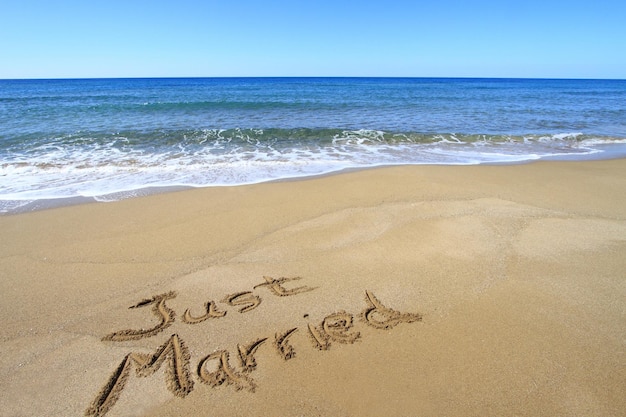 Foto gerade verheiratet, geschrieben am goldenen sandstrand