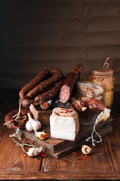 Foto geräucherte schweinswurst. babyrippen, weißbrot, maisbrot, gebackene bohnen, kartoffelsalat usw. traditionell verschiedene geräucherte und grillfleisch. auswahl an aufschnittwürsten mit knoblauch und pfeffer