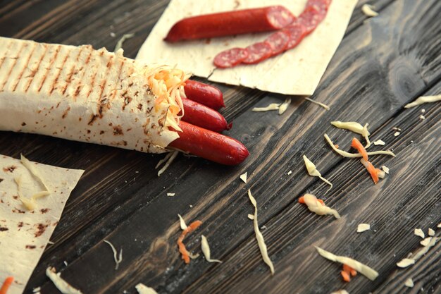 Geräucherte Wurst in Fladenbrot auf einem Holztisch