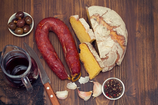 Geräucherte Wurstchorizo mit Maisbrot auf hölzernem Hintergrund