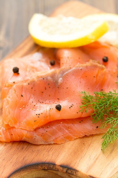 Geräucherter Lachs mit schwarzem Pfeffer auf Holztisch