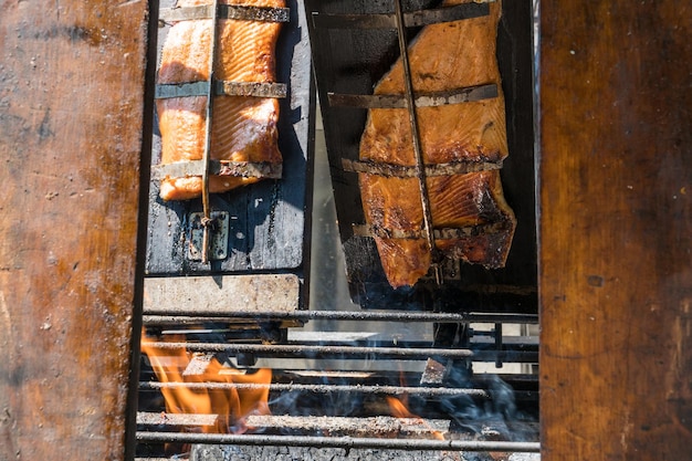 Geräuchertes Lachsfilet auf Holzbrettern auf offenem Feuer zubereitet
