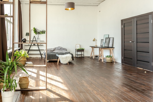 Geräumiges Studio-Apartment mit Holz und Weiß dekoriert. Minimalistisches Design mit riesigen Fenstern im Sonnenlicht. Küchenbereich und Wohnbereich
