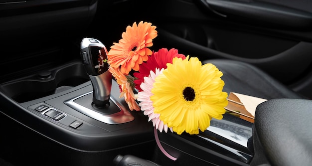 Gerberas en el interior del coche en la caja de cambios