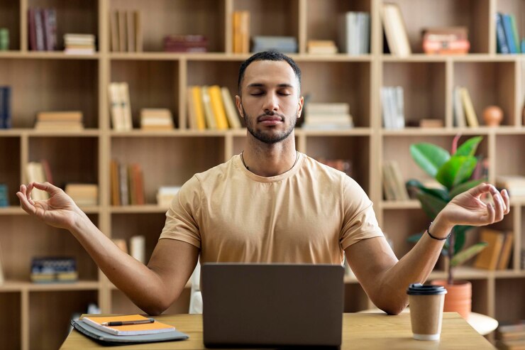 Foto gerenciamento do estresse no local de trabalho homem árabe calmo meditando com os olhos fechados na frente do laptop sentado na mesa em casa