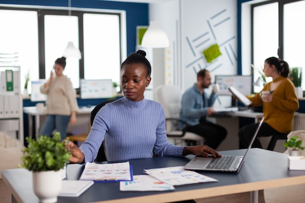 Gerente africano y compañeros de trabajo en la oficina corporativa concentrados en nuevos negocios