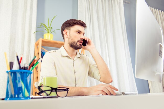 Gerente alegre exitoso hablando por teléfono con sus clientes