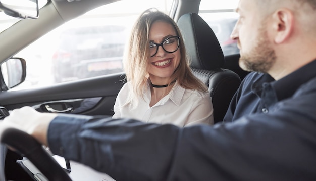 Foto gerente assistente dando conselhos ao cliente em salão de automóveis