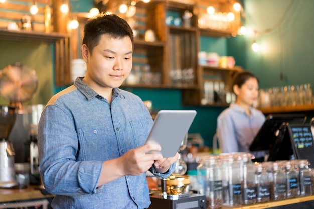 Gerente de cafetería confía en usar un dispositivo moderno en el lugar de trabajo