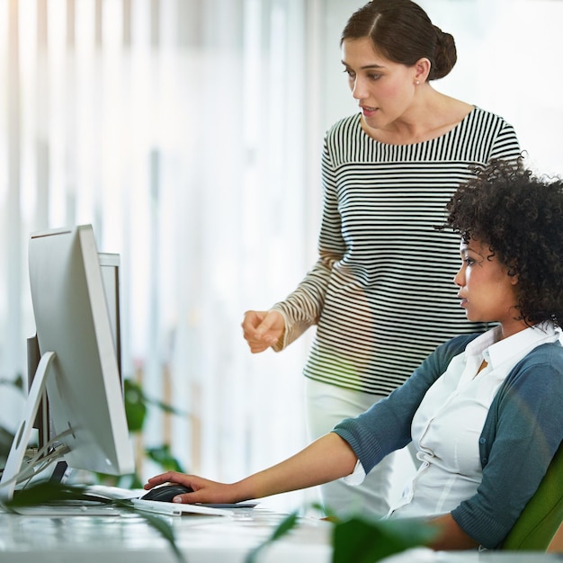 Un gerente de capacitación habla sobre un proyecto de colaboración en línea con un asistente interno mirando una pantalla de monitor de escritorio Mujer de negocios discutiendo la última estrategia de redes sociales o analizando las tendencias de SEO