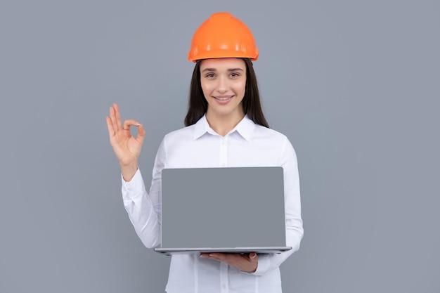 Gerente de construcción de mujer joven Retrato aislado de constructor de mujer con casco de protección y computadora portátil