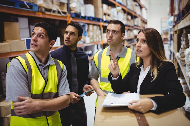 Gerente de armazém e trabalhadores conversando no armazém