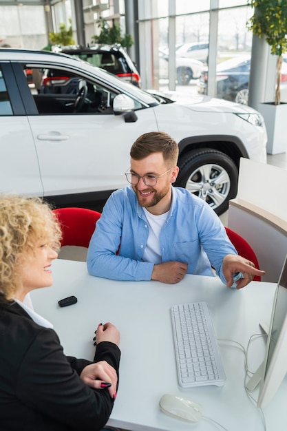 Gerente de concessionária de automóveis com cliente no computador