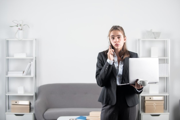 Gerente de escritório de mulher de negócios com telefone na mesa de escritório jovem empresária no local de trabalho no escritório