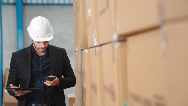 Gerente de fábrica usando computador tablet em armazém ou fábrica. Conceito de gestão da cadeia de abastecimento e indústria.