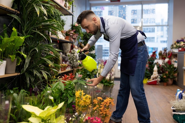 Gerente de loja de flores no centro de jardinagem cuidando de plantas