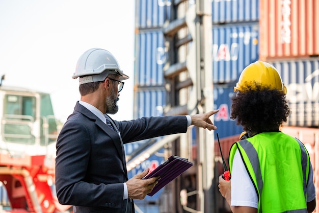 Foto gerente de ponto e comando com capataz para controlar contêineres no local de trabalho de distribuição de carga doca. análise de engenheiro para envio ao cliente.