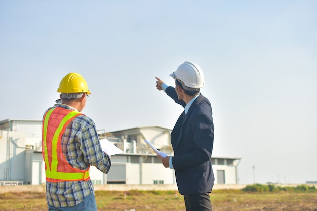 Gerente de projeto, levando com o engenheiro, plano de construção, projeto, construção de fábrica