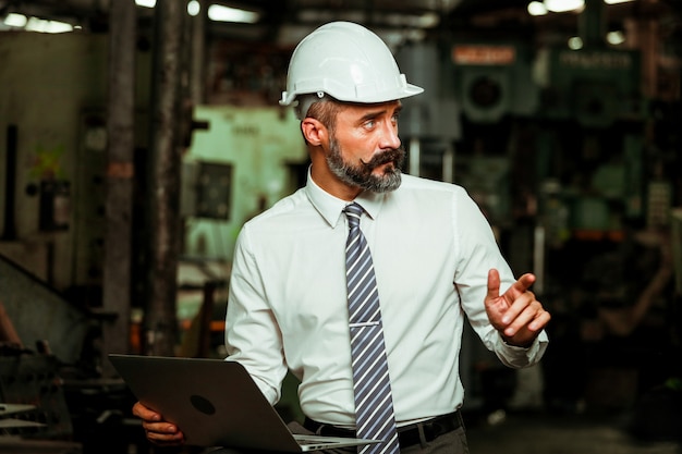 Foto gerente de projeto sênior trabalhando em fábrica industrial