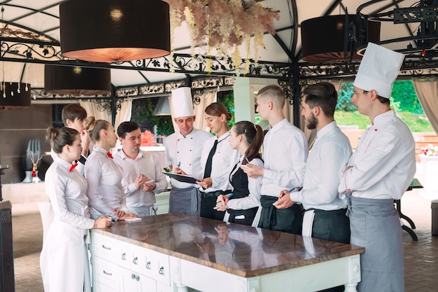 Gerente de restaurante e sua equipe no terraço, interagindo com o chefe de cozinha no restaurante,