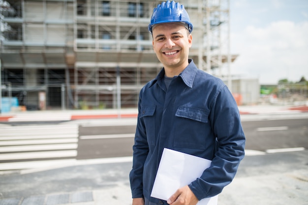 Gerente de site na frente de um canteiro de obras