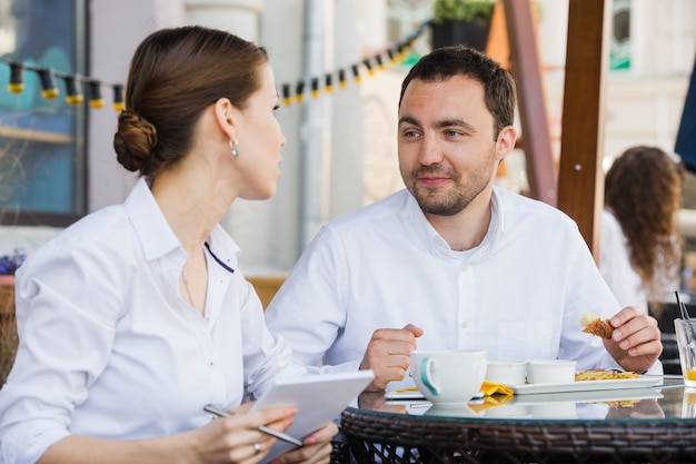 Gerente de sucesso sentado em um almoço de negócios com um colega