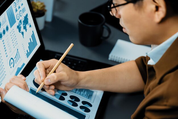 Gerente de trabalho de colheita com foco em negócios de papelada comparando infobahn de laptop