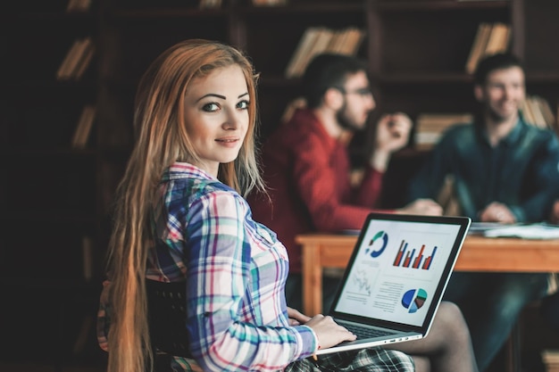 Foto gerente de vendas trabalhando em um laptop com um relatório de marketing