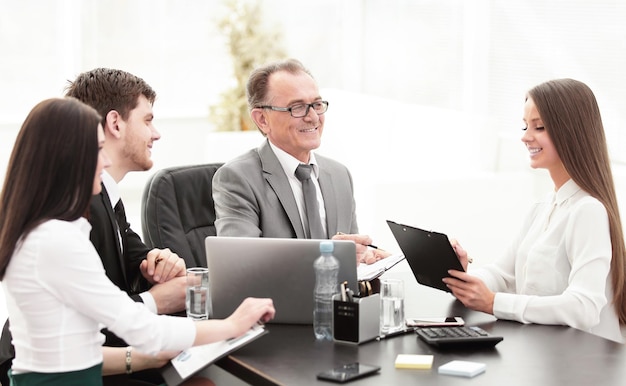 Gerente discutindo questões de trabalho com seus assistentes atrás de uma mesa