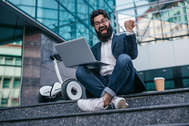 Gerente emocionado con laptop celebrando el éxito