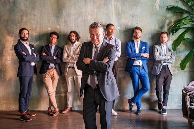 Foto el gerente de la empresa empoderado con sus jóvenes gerentes detrás de él apoyándolo