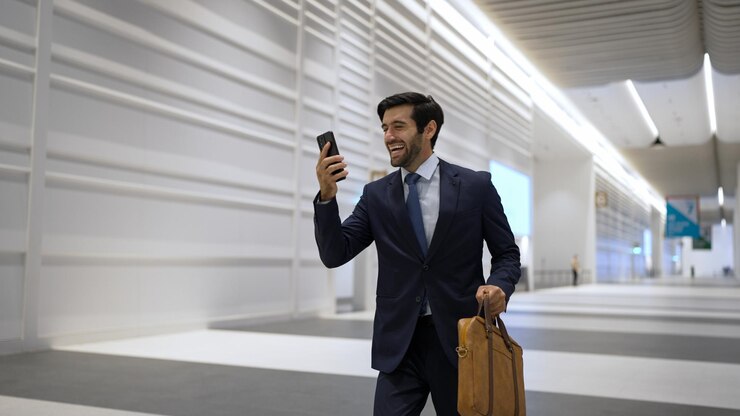 Foto gerente feliz recibe buenas noticias del teléfono con fondo blanco exultante
