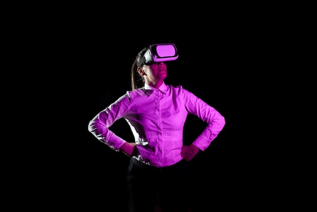 Gerente femenina que usa auriculares de realidad virtual y toma capacitación profesional a través de tecnología moderna La luz cae sobre una mujer con los brazos en jarras usando un dispositivo futurista