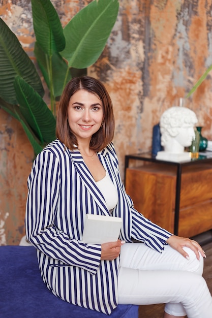 Gerente de floristería o diseñador mujer sentada en su oficina con el libro.