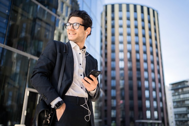 Un gerente con gafas, un hombre que usa un teléfono, escribe un mensaje en el chat de un colega de trabajo.