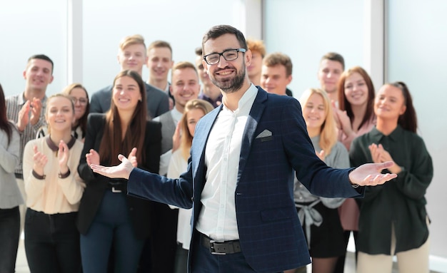 Gerente y un grupo de diversos empleados de pie en la nueva oficina