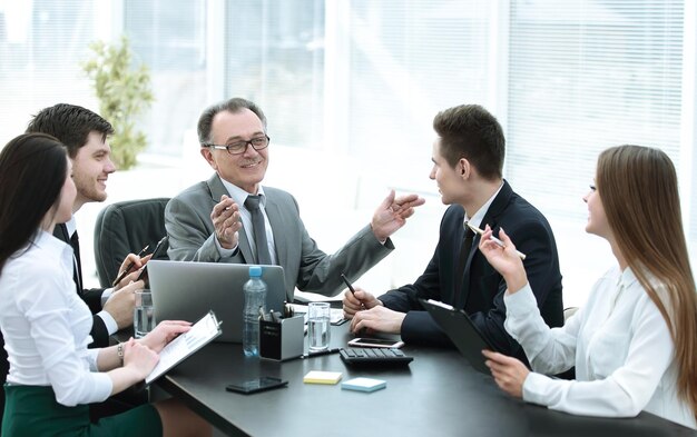 Gerente y grupo empresarial discutiendo documentos financieros