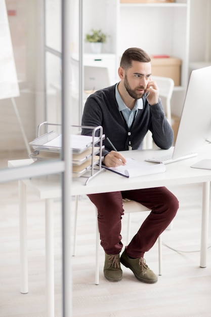 Gerente hablando por teléfono en el lugar de trabajo