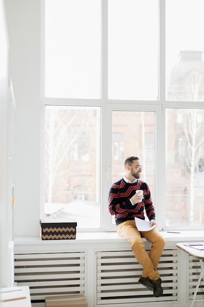 Foto gerente de hipster relajado feliz en la oficina