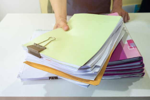 Gerente de hombre está presentando documentos de cuenta en frente de escritorio blanco