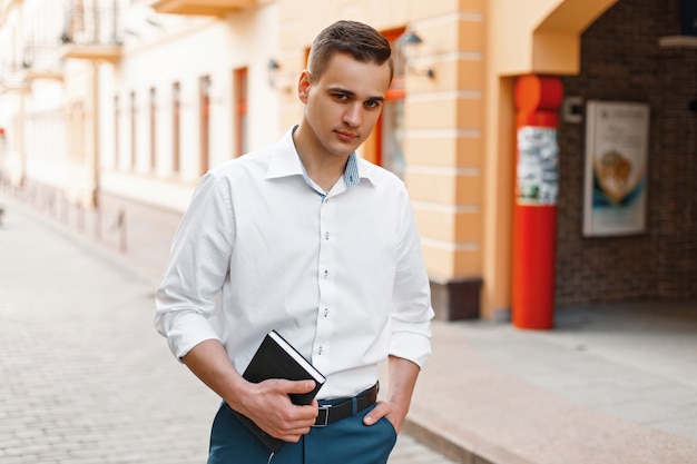 Gerente de hombre guapo elegante con una camisa blanca en la ciudad