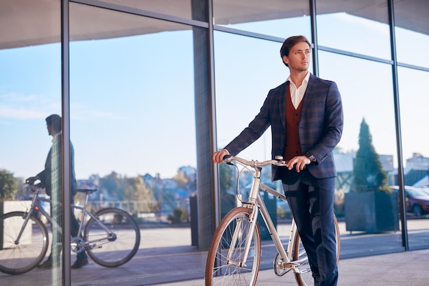 Gerente masculino con bicicleta en las calles de la ciudad