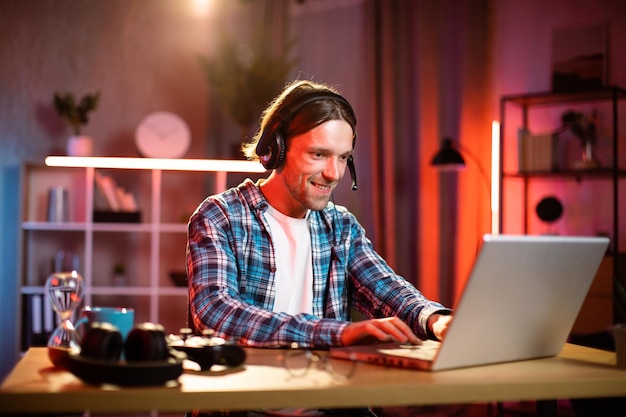 Gerente masculino enfocado en reunión de trabajo líder de auriculares a través de videollamada en la computadora portátil